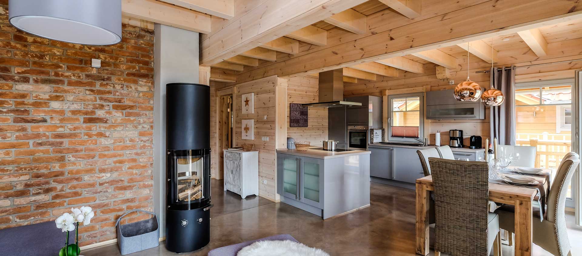 Lodge Blickfang – offener Wohn- und Essbereich mit Kaminofen